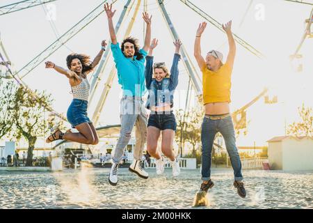 Gruppe junger Leute, die auf den Sand springen, Freunde, die Spaß bei einer Strandparty haben, Freiheit und fröhliches Sommerbild, londoner Leute reisen Stockfoto