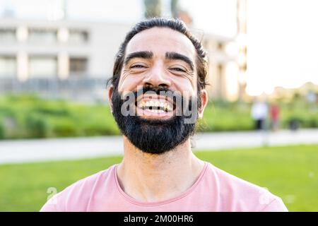 Kopfschuss eines hispanischen bärtigen Mannes, der in die Kamera lächelt Stockfoto