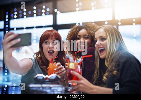 Frauen, Freunde und Telefon-Selfie im Club mit Drinks, Spaß oder Freundschaft. Nacht, Feier und eine Gruppe von Mädchen, die ein Foto mit ihrem Smartphone machen Stockfoto