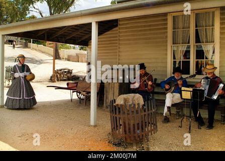 Ballarat, VIC, Australien - 23. Januar 2008: Unidentifizierte Frau in traditioneller Kleidung der Pionierzeit und Musiker auf Sovereign Hill - ein wiederaufgebauter Gol Stockfoto