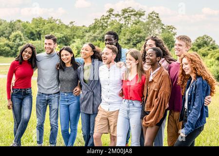 Große Gruppe von Menschen der Z-Generation, junge Universitätsstudenten haben Spaß im Freien in einem Stadtpark Stockfoto