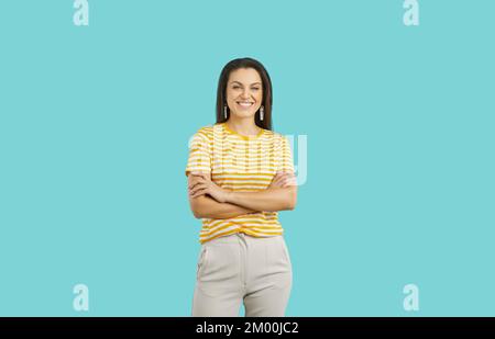 Glückliche attraktive junge Frau in lässiger Kleidung, isoliert auf blauem Hintergrund Stockfoto