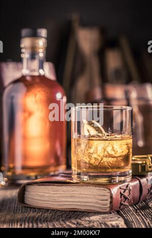 Edler und gereifter Whisky auf Felsen mit goldener Flasche. Single Malt Whisky mit Eisgestein. Stockfoto