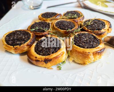 Schwarzer Pudding mit Reis auf Blätterteig, köstliches spanisches Gericht Stockfoto