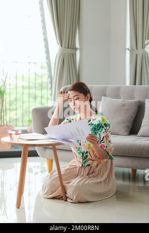 Zufrieden Student Mädchen macht Hausaufgaben, während auf dem Boden zu Hause sitzen Stockfoto