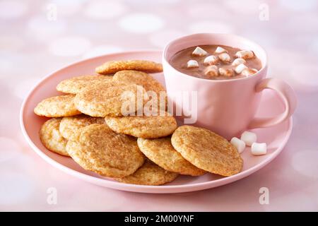 Hausgemachte Snickerdoodle-Kekse und heiße Schokolade mit Marshmallows auf einem rosafarbenen Teller und einer Tasse mit Kopierbereich Stockfoto