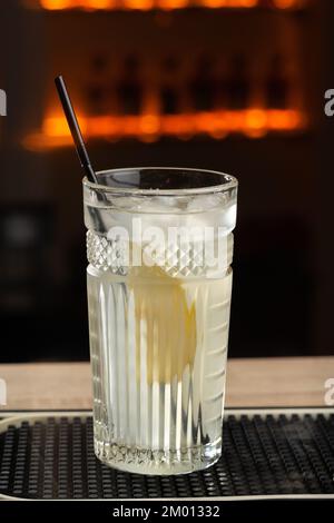 Seitlicher Blick auf frischen, kühlen Cocktail Gin Tonic mit einer Scheibe Birne und Eis in einem Glas auf dem Holztisch. Speicherplatz kopieren Stockfoto