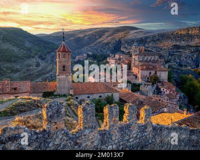 Blick auf Albarracin bei Sonnenuntergang mit seinen Mauern und die Kirche Santa Maria y Santiago im Vordergrund. Teruel, Spanien. Stockfoto