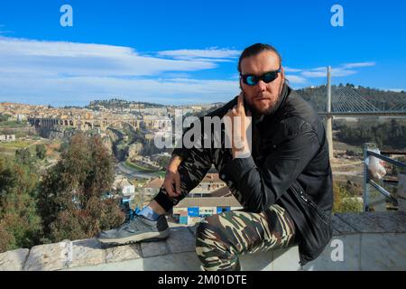 Weißer Tourist, der mit einer alten Brücke posiert, Sidi Rached in Konstantine, Algerien Stockfoto
