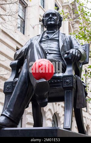 Royal Exchange, City of London, Großbritannien. 3.. Dezember 2022. Ein roter Fußball wurde der Statue von W. W. Story of George Peabody vor der Royal Exchange in der City of London hinzugefügt, die enthüllt wurde (ohne Fußball!) Im Juli 1869 kurz vor Peabodys Tod. George Peabody (18. Februar 1795 bis 4. November 1869) war ein amerikanischer Finanzier und Philanthrop. Gesehen während der FIFA-Weltmeisterschaft 2022 in Katar Stockfoto