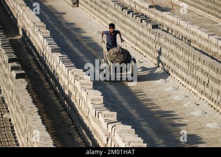 Dhaka, Dhaka, Bangladesch. 3.. Dezember 2022. Saisonarbeitnehmer arbeiten am 3. Dezember 2022 in einer ungesunden Umgebung auf einem Ziegelsteinfeld in Dhaka, Bangladesch. (Kreditbild: © Abu Sufian Jewel/ZUMA Press Wire) Stockfoto