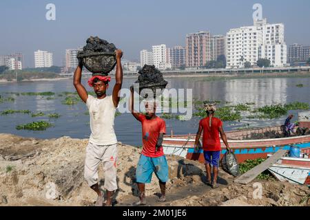 Dhaka, Dhaka, Bangladesch. 3.. Dezember 2022. Dr. Shahidul (30) in der Mitte, der aufgrund von Elektrokurzschlüssen seine eine Hand verlor, arbeitet nun als saisonale Wanderarbeitnehmer auf einem Ziegelsteinplatz. Jedes Jahr arbeiten saisonale Wanderarbeitnehmer am 3. Dezember 2022 in einer ungesunden Umgebung auf dem Ziegelsteinfeld in Dhaka, Bangladesch. (Kreditbild: © Abu Sufian Jewel/ZUMA Press Wire) Stockfoto