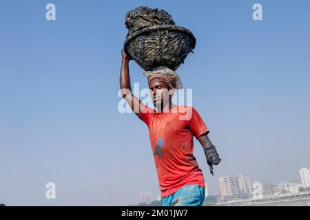 Dhaka, Dhaka, Bangladesch. 3.. Dezember 2022. Dr. Shahidul (30), der aufgrund von Elektrokurzschlüssen seine eine Hand verlor, arbeitet nun als saisonale Wanderarbeitnehmer auf einem Ziegelsteinplatz. Jedes Jahr arbeiten saisonale Wanderarbeitnehmer am 3. Dezember 2022 in einer ungesunden Umgebung auf dem Ziegelsteinfeld in Dhaka, Bangladesch. (Kreditbild: © Abu Sufian Jewel/ZUMA Press Wire) Stockfoto