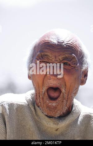 Grauhaariger älterer Mann, der lässig weiß süßer ist, über einem isolierten Hintergrund steht, gelangweilt gähnt, müde, ruhelos und schläfrig Stockfoto