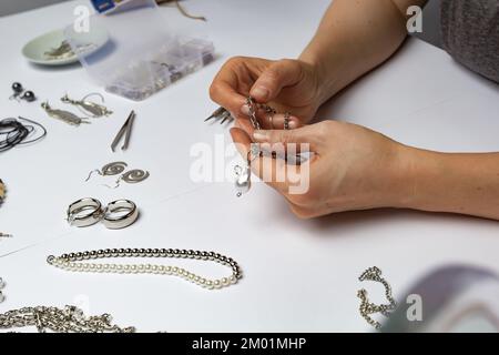 Der Designer stellt handgefertigten Schmuck am Arbeitsplatz her. Stockfoto