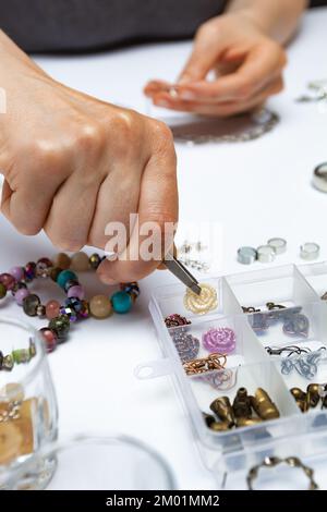 Der Designer stellt handgefertigten Schmuck am Arbeitsplatz her. Stockfoto