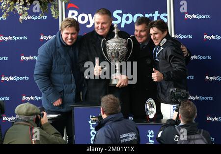 Jockey Harry Skelton (rechts), Trainer Dan Skelton (links) und Eigentümer Darren Yates (zweite links) feiern, nachdem das Pferd Ashtown Lad den Boylesports Becher Chase (Premier Handicap) während des Boylesports Becher Chase Day auf der Aintree Rennbahn Merseyside gewonnen hat. Foto: Samstag, 3. Dezember 2022. Stockfoto