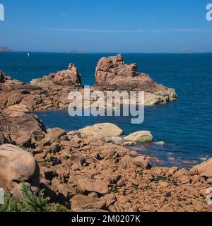 Monolithische Blöcke aus rosafarbenem Granit in den Cotes d'Armor in der Bretagne, Frankreich. Rosafarbene Granitküste Stockfoto