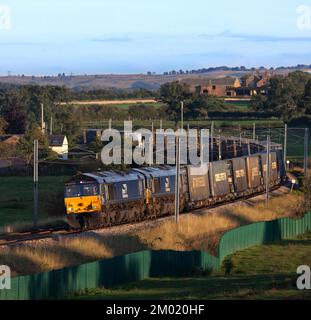 2 Direktschienenverkehr Diesellokomotiven der Klasse 66, die einen intermodalen Containerzug auf der Hauptstrecke der elektrifizierten Westküste in Cumbria transportieren Stockfoto