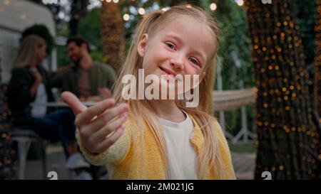 Portrait niedliches kleines Kind draußen campen kleines Kind Mädchen Baby Schulmädchen Tochter winkt Hand einladende Willkommensgeste hierher laden Kaukasier ein Stockfoto