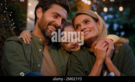 Eltern Weißer Mann Vater und Frau Mutter reden sprechende Unterhaltung kleines Kind Mädchen läuft kuschelig umarmen Umarmung umarmen kuscheln Stockfoto