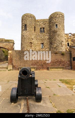 Roggenburg mit dem Ypern-Turm aus dem 14.. Jahrhundert, ein kleiner Bergfried. Im Vordergrund befindet sich ein Kanon an der Küste auf den Festungsmauern. Ansicht aus niedrigem Winkel. Stockfoto