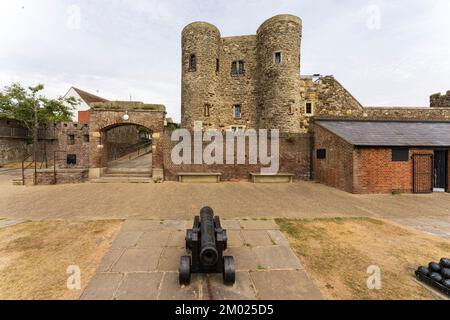 Roggenburg mit dem Ypern-Turm aus dem 14.. Jahrhundert, ein kleiner Bergfried. Im Vordergrund befindet sich ein Kanon an der Küste auf den Festungsmauern. Großer Blickwinkel. Stockfoto