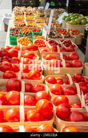 Große Auswahl an Tomaten im Korb auf dem Bauernmarkt. Körbe mit Tomaten und Kirschtomaten. Stockfoto