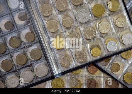 Сoins aus verschiedenen Ländern sind in durchsichtigen Blisterpackungen angeordnet. Seite aus Album voll mit alten Münzen. Münzlagermethode. Numismatische Sammlung. Bis Stockfoto