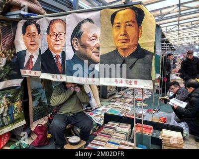 Poster früherer chinesischer Führer (von rechts nach links) Mao Zedong, Deng Xiaoping, Jiang Zemin und Hu Yaobang sind über einem Second-Hand-Bücherstand zum Verkauf auf dem Panjiayuan Flohmarkt, Chinas größtem und vollständigsten, billigsten und beliebtesten Markt, der Second-Hand-Waren und Kurios verkauft, in der Innenstadt von Peking. China, am Samstag. 23. Februar 2019. 23FEB19 SCMP/Simon Song Stockfoto