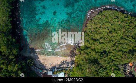 Luftblick auf den herrlichen Sandstrand und die tropische Lagune mit Korallenriff umgeben von tropischem Grün Stockfoto