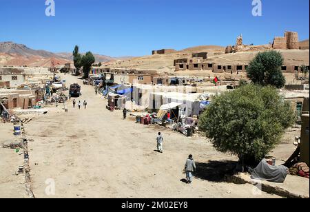 Die staubige Hauptstraße in Lal Wa Sarjangal, Provinz Ghor, Zentralafghanistan. Die Gebäude und unbefestigten Straßen sind typisch für abgelegene Städte in Afghanistan. Stockfoto