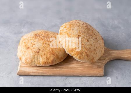 Pita-Brot auf Holzbrett auf neutralem Hintergrund. Georgianische Küche. Spanisches Essen. Nationale Küche. Traditionelles Gericht Stockfoto