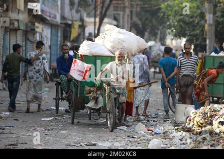 Dhaka, Bangladesch. 3.. Dezember 2022. Nachdem er den Müll von verschiedenen Orten abgeholt hat, bringt ihn eine Person in einen Lieferwagen, um ihn in der Müllhalde am Ufer des Buriganga River in Dhaka, Bangladesch, am 3. Dezember 2022 zu entsorgen. Personen, die an der Sammlung und dem Transport dieser Abfälle beteiligt sind, halten sich nicht an Hygienevorschriften. Kredit: ZUMA Press, Inc./Alamy Live News Stockfoto