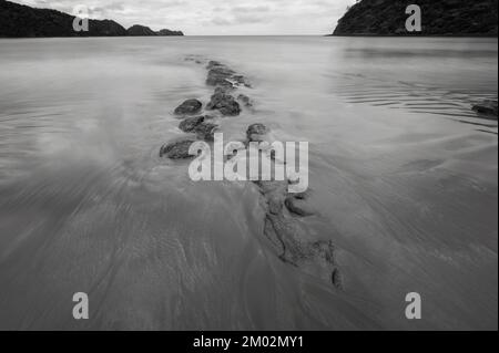 Weiches Wasser an der Meeresbucht in Schwarz und Weiß Stockfoto