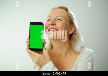 Gewinnen, um zu finden, was Freude Freude Freude Freude Freude Freude andere Emotionen Chroma Key Phone Grünes Bildschirmfeld für Werbung schöne Erwachsene glückliche Frau Stockfoto