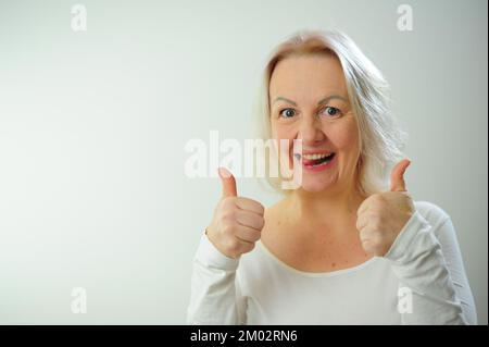 Empfehlung Angebot verlangen die Freude des Glücks der Anerkennung viel Platz für Textwerbung Eine Frau zeigt Klasse sie ist sehr zufrieden mit etwas und glücklich sie hebt die Daumen Stockfoto