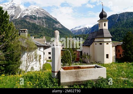 Malerische Schweizer Landschaft mit ihren malerischen alten Häusern und einer alten Kirche in der Region Engiadina Bassa, Schweizer Kanton Graubuenden in den schneebedeckten Schweizer Alpen Stockfoto