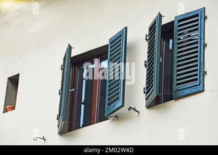 Zwei Fenster mit dunkelgrünen Fensterläden an der Fassade von Haus Nr. 8 an der Ecke von Toscanella und Sprone im quadratischen Passera in Florenz, Italien Stockfoto