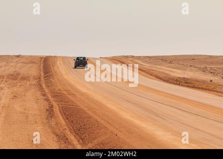 Swakopmund, Namibia - 02. Oktober 2018: Auto auf Schotter, namibische Straße. Namibische Wildnis. Stockfoto