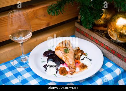 Gebackenes Hähnchen mit Scheiben gekochter Rüben, wilden Pilzen und Sahne-Sauce. Ein festliches Silvestergericht. Stockfoto