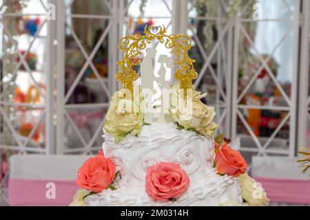 Hochzeitstorte mit Figuren von Frischvermählten und roten Rosen, Nahaufnahme Stockfoto