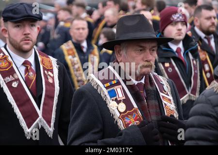 Londonderry, Großbritannien. Dezember 2022. Mitglieder der Apprentice Boys of Derry, Männer, große Gruppe mit purpurroten Insignien, Hüten und Wintermänteln, die bei der Schließung der Gates 2022 vormarschieren. Quelle: Steve Nimmons/Alamy Live News Stockfoto