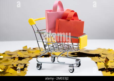 Einkaufstüten in einem kleinen Einkaufswagen, Verkaufskonzept. Stockfoto
