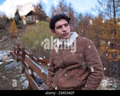 Attraktiver junger Mann in den Bergen im Herbst oder Winter Stockfoto