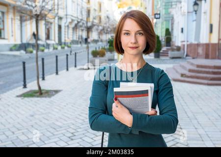 Außenporträt einer Schülerin mit Lehrbüchern in den Händen. Lernen, Bildungskonzept Stockfoto
