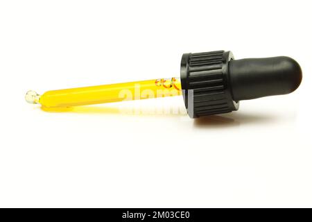 Ölpipette isoliert auf weißem Hintergrund. Natürlicher Essenzextrakt gelber Substanz im Tropfer Stockfoto