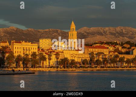 Der magische Sonnenuntergang in Split, Kroatien. Der Blick auf Split's Stadtböschung und Berge. Diokletianpalast-Turm bei Sonnenuntergang. Stockfoto