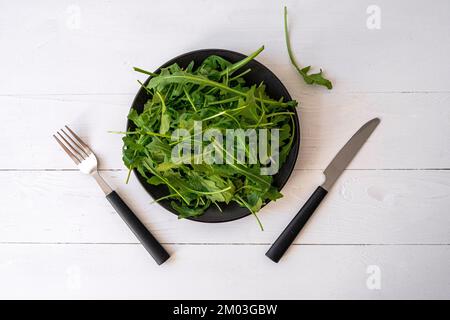 Frischer Rucola auf dem weißen Tisch Stockfoto