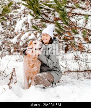 Golden Retriever Hund mit Mädchen im Winter Stockfoto